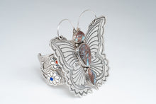 Load image into Gallery viewer, Angled front of bracelet showcasing a silver stamped butterfly with antennas and three turquoise stones. Side Cuff displays two flowers with one coral and one lapis stone.