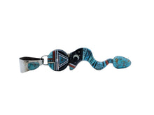 Load image into Gallery viewer, Side view of a pendant shaped like a snake made with turquoise, jet black stone, and sterling silver with a moon in the middle and a circular head with the design of a Navajo deity