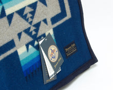 Load image into Gallery viewer, Pendleton Chief Joseph Blanket in Aegean featuring a traditional Native American-inspired geometric pattern with arrow motifs, folded neatly to show intricate design and soft wool texture. Tag View