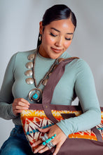 Load image into Gallery viewer, Young Adults Navajo Woman wearing a long-sleeve green t-shirt and is holding a Pendleton Tote. She is wearing a large turquoise butterfly ring on her left hand