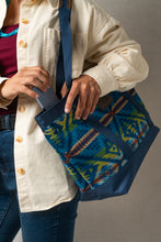 Load image into Gallery viewer, Person holding a blue Pendleton bag with geometric pattern and pulling out a blue phone from the bag