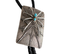 Load image into Gallery viewer, Silver spider rectangular bolo tie with two turquoise stones as the spiders body on a white background