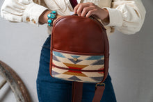 Load image into Gallery viewer, Person wearing a turquoise bracelet holding a Pendleton brown backpack with a colorful woven pattern