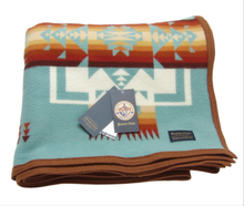 Load image into Gallery viewer, Pendleton Chief Joseph Blanket in aqua, featuring a traditional Native American-inspired geometric pattern with arrow motifs, folded neatly to show intricate design and soft wool texture. front View