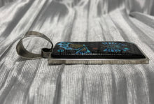 Load image into Gallery viewer, A rectangular pendant with a silver frame and loop for a chain. side view showcasing its flat inlay