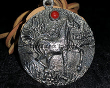 Load image into Gallery viewer, A circle silver pendant with a sand cast horse and one coral stone, with a tan leather strap. Displayed on top of a black cloth