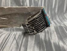 Load image into Gallery viewer, Displayed is a silver tufa cobbletone bracelet, on a silver shiny sheet side view
