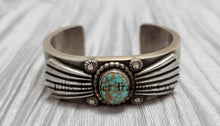 Load image into Gallery viewer, Heavy silver bracelet, with a center Carico Lake Turquoise stone, with an overlay design, on top of a shiny silver sheet