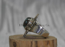 Load image into Gallery viewer, Silver ring, with zigzag 14k overlay design with round Bisbee turquoise in center, on wooden display side view,