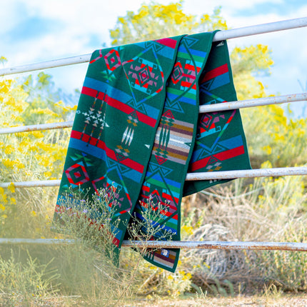Forest Green Pendleton Blanket Hanging on Cattle Gate with New Mexico Clouds in background
