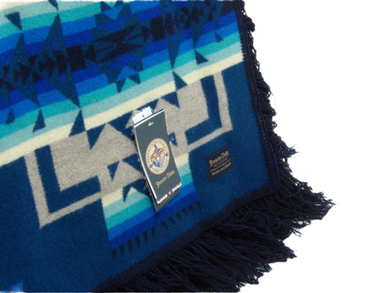 Pendleton Chief Joseph Blanket in Aegean featuring a traditional Native American-inspired geometric pattern with arrow motifs, folded neatly to show intricate design and soft wool texture, Tag view 