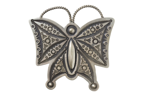 Hand stamped silver butterfly pendant on a white background