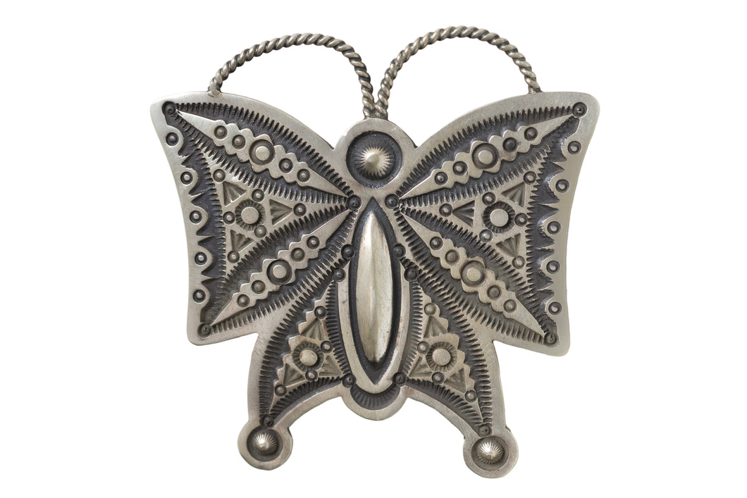 Hand stamped silver butterfly pendant on a white background