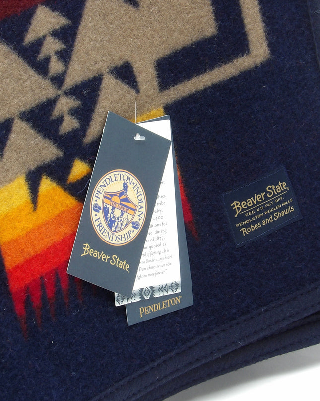 Pendleton Chief Joseph Blanket in indigo featuring a traditional Native American-inspired geometric pattern with arrow motifs, folded neatly to show intricate design and soft wool texture. Tag View 