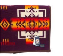 Load image into Gallery viewer, Pendleton Chief Joseph Blanket in Maroon featuring a traditional Native American-inspired geometric pattern with arrow motifs, folded neatly to show intricate design and soft wool texture. Front view
