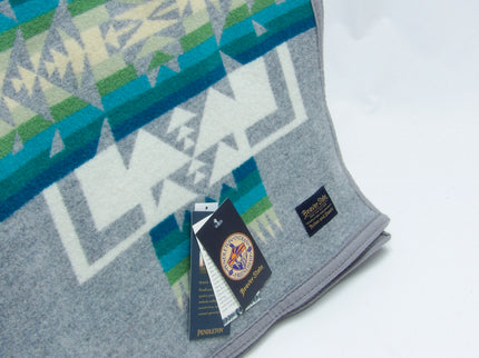 Pendleton Chief Joseph robe  in Grey featuring a traditional Native American-inspired geometric pattern with arrow motifs, folded neatly to show intricate design and soft wool texture, tag view