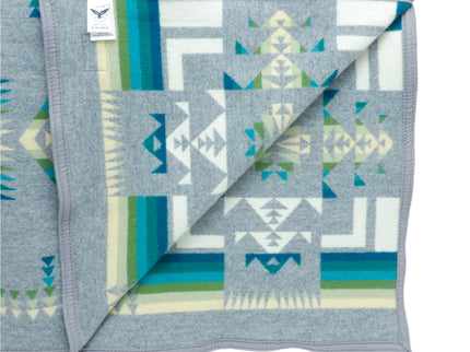 Pendleton Chief Joseph Blanket in grey featuring a traditional Native American-inspired geometric pattern with arrow motifs, folded neatly to show intricate design and soft wool texture, inside view