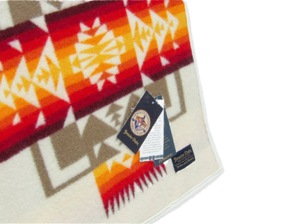 Pendleton Chief Joseph Blanket in Ivory featuring a traditional Native American-inspired geometric pattern with arrow motifs, folded neatly to show intricate design and soft wool texture, tag view