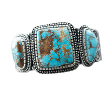 Load image into Gallery viewer, Center close up of Royston Turquoise with brown matrix, in center of silver bracelet by Navajo Silversmith Matthew Charley, on a solid white background. 
