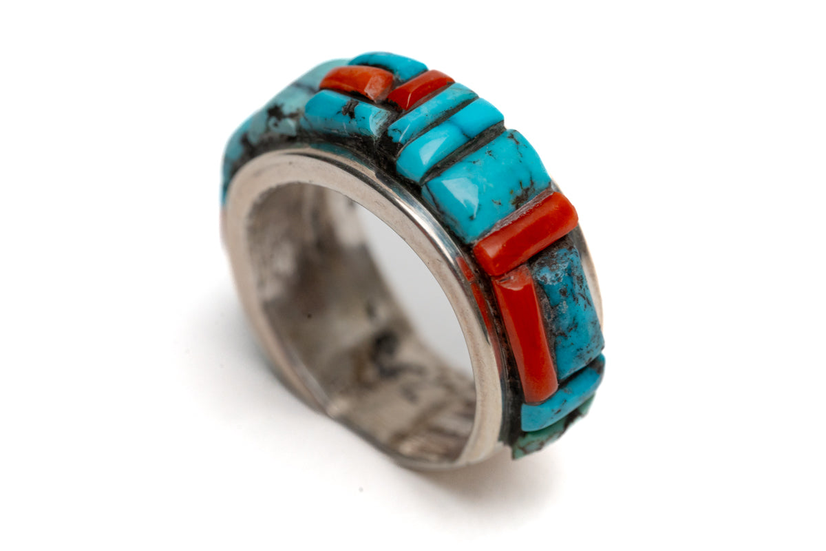Ring with turquoise and coral stone inlay on a white background