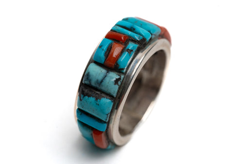 Ring with turquoise and coral stone inlay on a white background