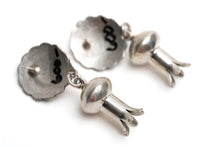 Load image into Gallery viewer, Close up of a pair of circular silver earrings with dangling silver shaped like flower stems a white background

