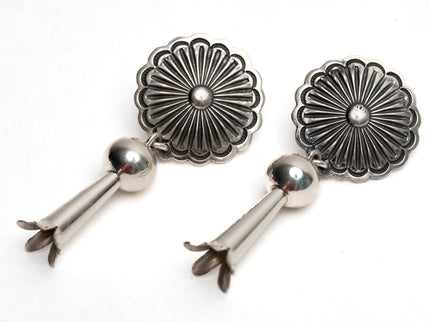 Pair of Native American silver earrings with floral designs on a white background
