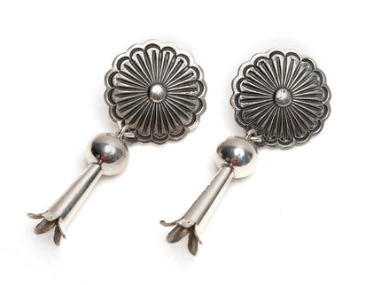 Pair of Native American silver earrings with floral designs on a white background