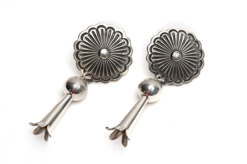 Pair of Native American silver earrings with floral designs on a white background