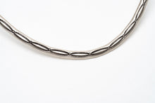 Load image into Gallery viewer, close up of stamp lines on a silver choker necklace on a white background
