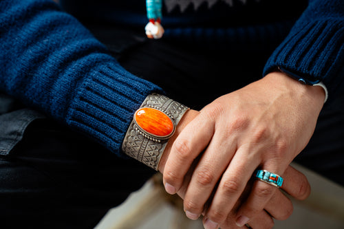 Close-up of male hands wearing a Native American bracelet and ring