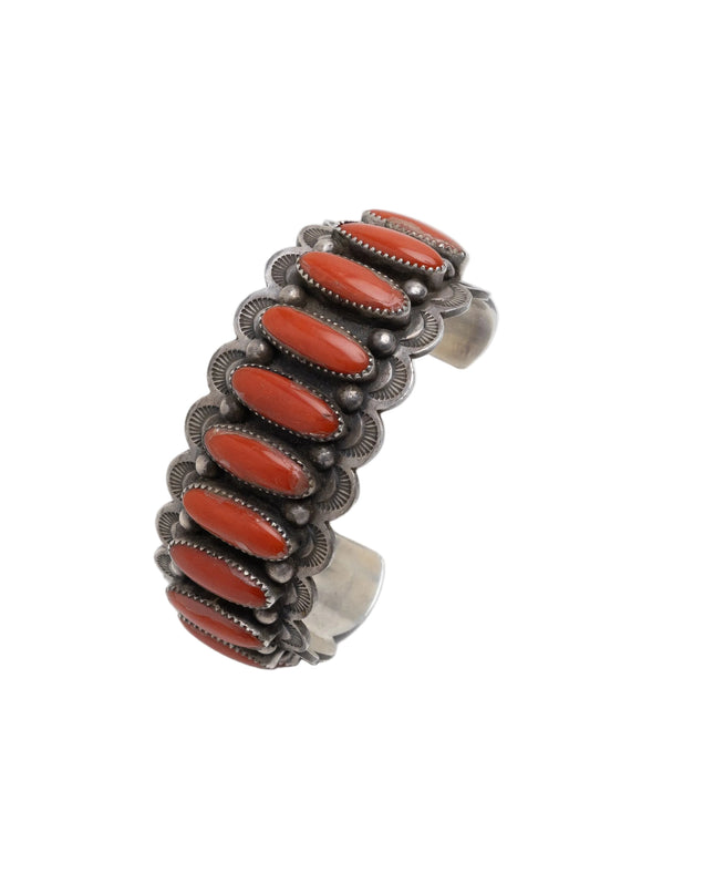 Navajo Silver cuff with 11 red coral stones on a white background