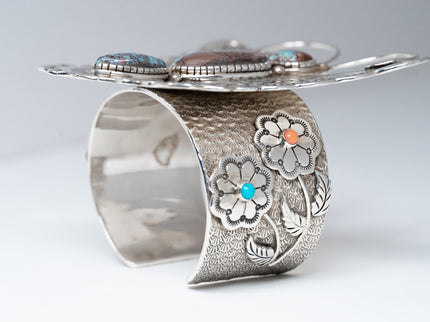 Standing Side View of Bracelet, two silver flowers with one stone each, Sleeping beauty Turquoise, and a pink coral stone