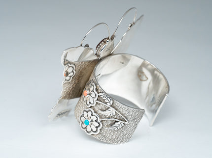 Shiny Back side of bracelet show casing bottom stems of flowers with Sleeping Beauty Turquoise and Pink Coral.