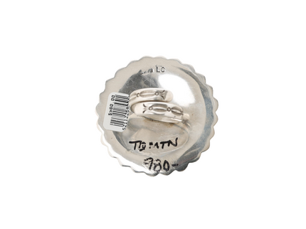 Back of a sterling silver ring with a adjustable band that has stamps on a white background