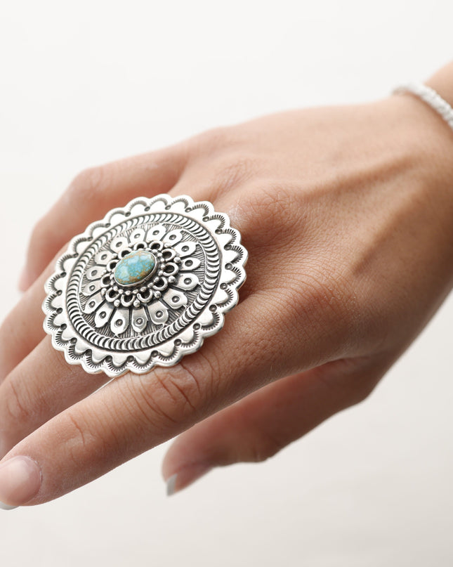 Native American sterling silver ring with a turquoise stone on a hand against a white background
