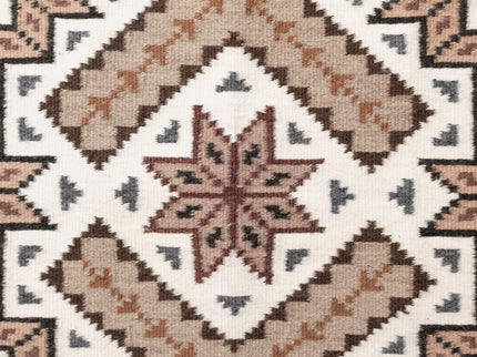 Center close-up of a navajo patterned rug with geometric design