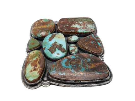 Turquoise stone belt buckle with nine stones on a white background