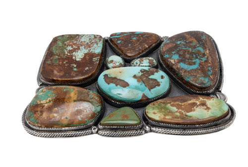 Belt buckle with nine Royston genstones inlay on a white background