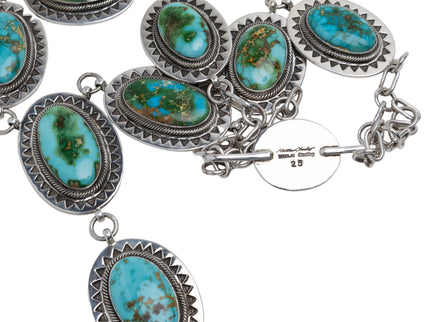 Native American Silver necklace with turquoise stones on a light gray background