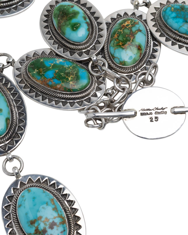 Native American Silver necklace with turquoise stones on a light gray background
