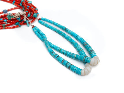 Close up view of single Native American necklace with nine strands of Mediterranean coral with sleeping beauty, Royston and Kingman Turquoise stones, and Lapis on a white background