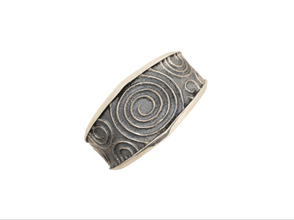 Silver cuff bracelet with spiral pattern on a white background