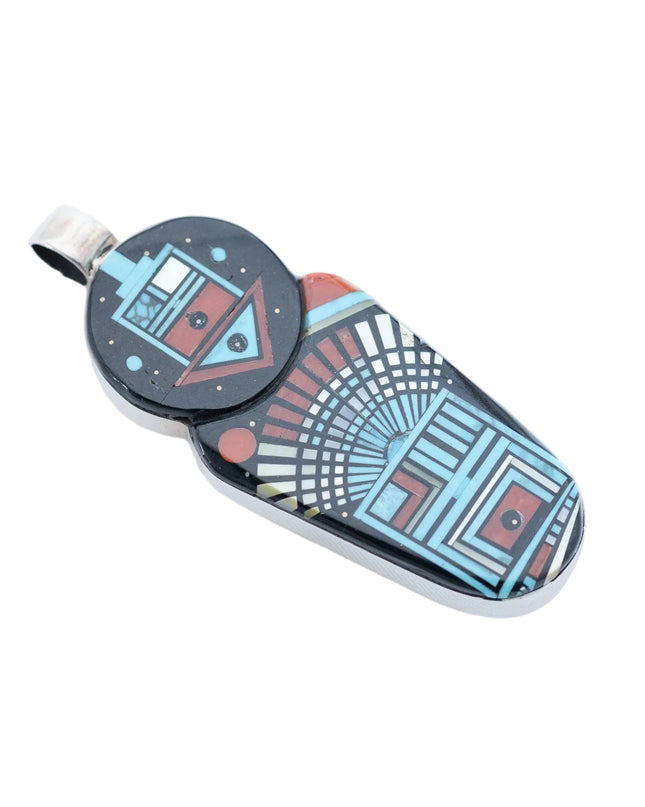 Colorful inlay Navajo pendant with deity images on a white background