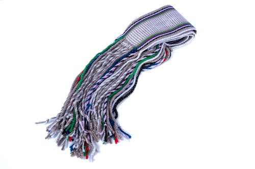 A hand woven Navajo gray and silver sash belt with fringed ends.