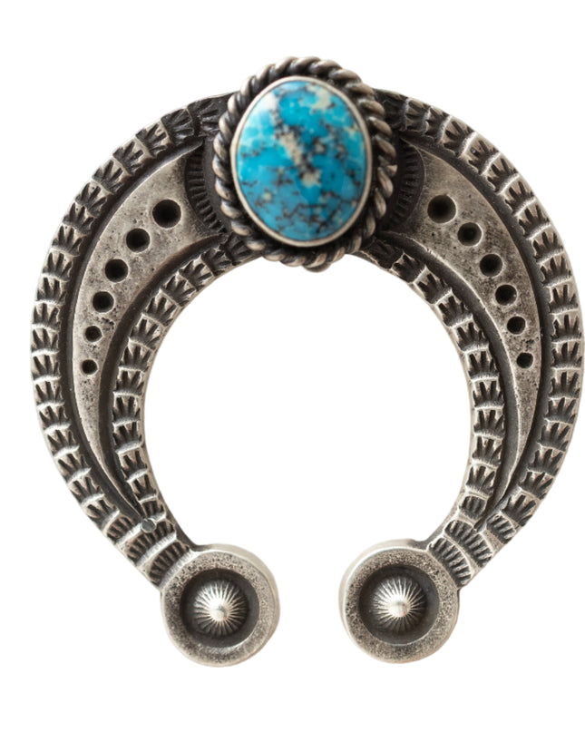 Silver u-shaped jewelry piece with a turquoise stone and stamp work on a light gray background