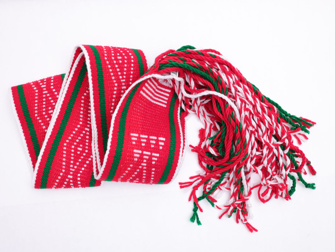 Red and white traditional sash with two green lines folded in a v shape line on a white background