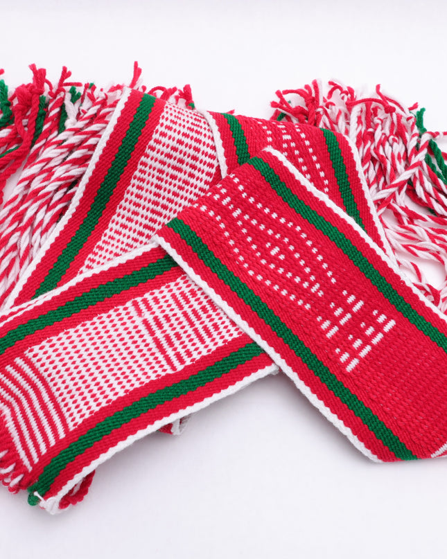 Red and white traditional sash with two green lines laid out on a white background