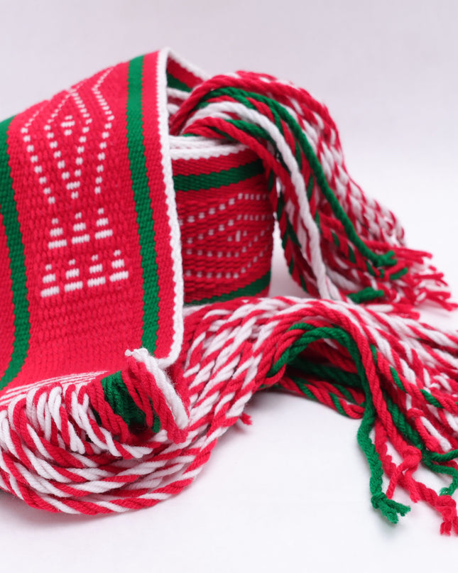 Red and white traditional sash with two green lines rolled up on a white background