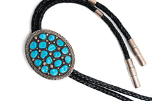 Load image into Gallery viewer, Bolo tie with 17 Turquoise stones on a round silver center with black leather cord on a white background
